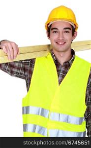 portrait of young joiner carrying planks over shoulder
