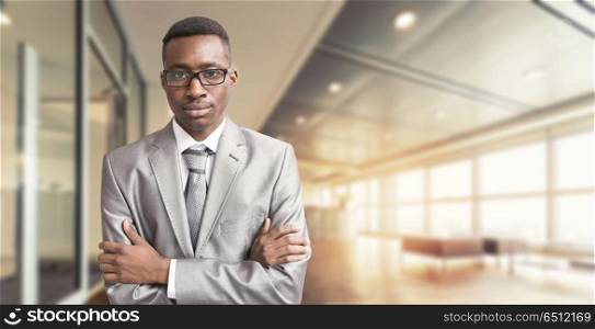 Portrait of young junior businessman in front of his big modern office. Young businessman in his office