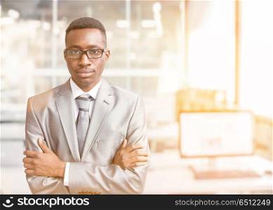 Portrait of young junior businessman in front of his big modern office,. Young businessman in his office