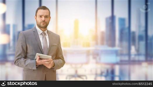 Portrait of young junior businessman using tablet in front of his big modern office. Young businessman in his office