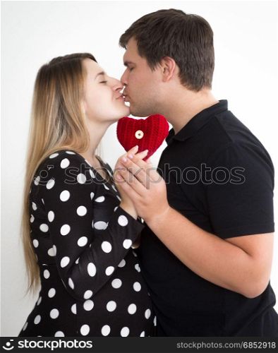 Portrait of young kissing pregnant couple in stylish clothes