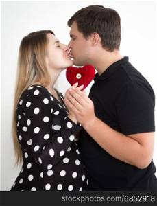 Portrait of young kissing pregnant couple in stylish clothes