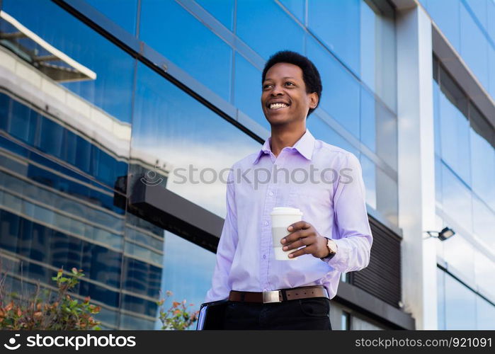 Portrait of young latin businessman holding coffee cup outside of office.