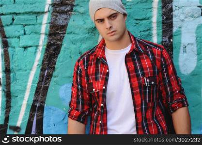 Portrait of young latin man against a colorful wall. Urban style.. Portrait of a young latin man