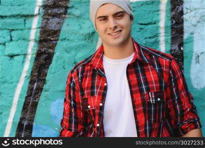 Portrait of young latin man against a colorful wall. Urban style.. Portrait of a young latin man