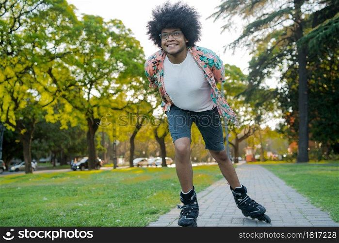 Portrait of young latin man enjoying while rollerskating outdoors on the street. Sports concept. Urban concept.
