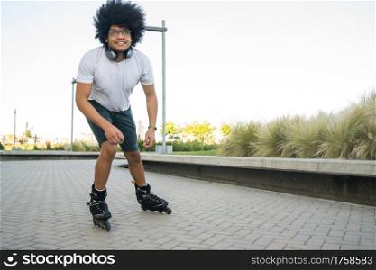 Portrait of young latin man rollerskating outdoors on the street. Sports concept. Urban concept.