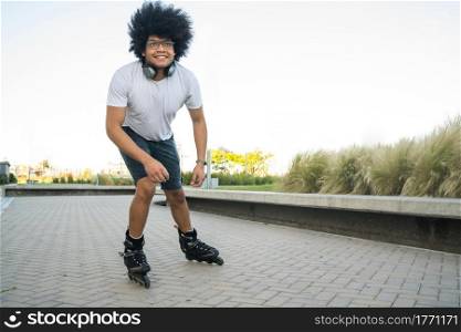 Portrait of young latin man rollerskating outdoors on the street. Sports concept. Urban concept.