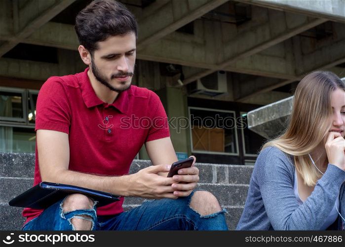 Portrait of young latin man using his smartphone. Outdoors.