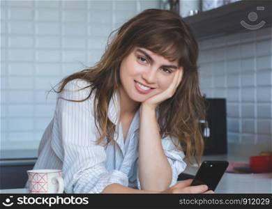 Portrait of young latin woman relaxing in the kitchen.