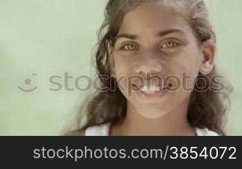 Portrait of young latina, young girl with green eyes smiling and looking at camera