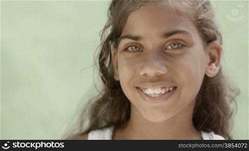 Portrait of young latina, young girl with green eyes smiling and looking at camera