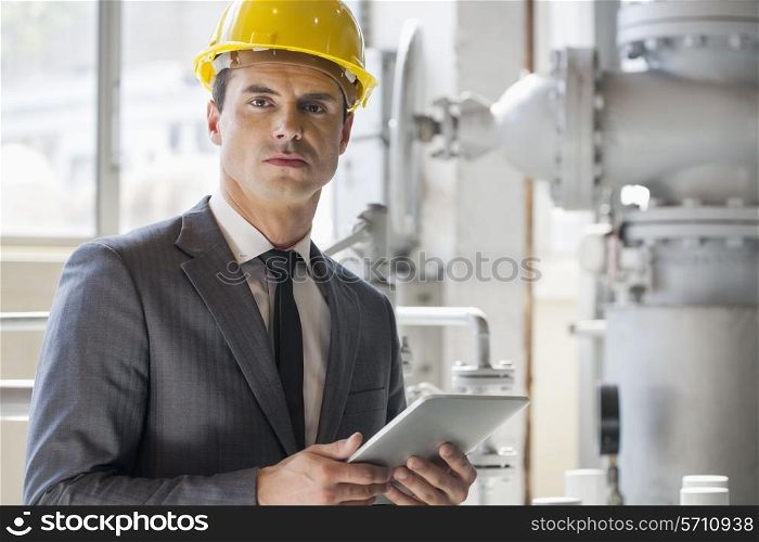 Portrait of young male architect holding tablet computer in industry
