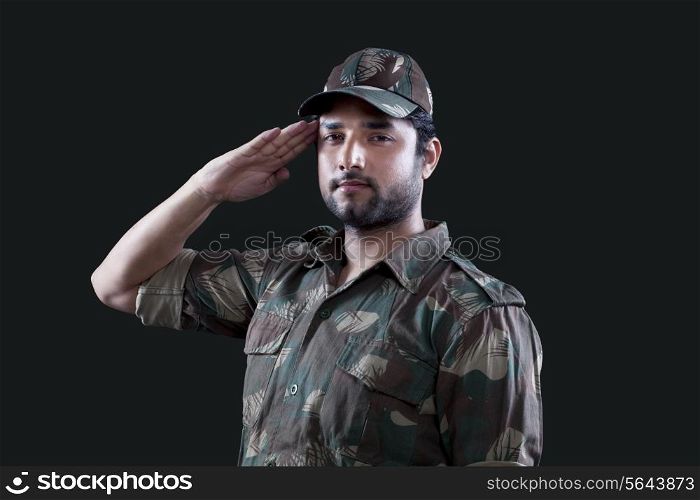 Portrait of young male soldier saluting