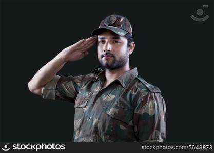 Portrait of young male soldier saluting