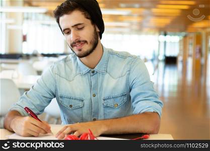 Portrait of Young male student working in the university library.