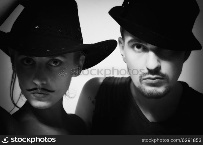 portrait of young man and woman with mustache wearing hats