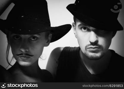 portrait of young man and woman with mustache wearing hats