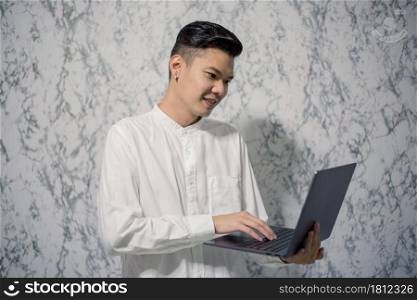 Portrait of young man businessman is holding a notebook and smiling at home