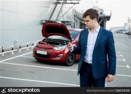 Portrait of young man calling technical car service