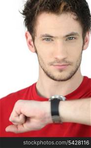 portrait of young man consulting his watch