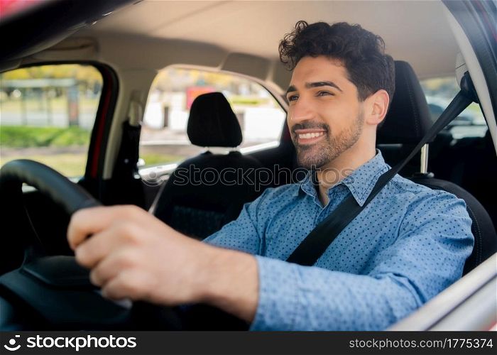 Portrait of young man driving his car on his way to work. Transport concept.