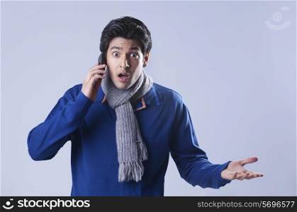 Portrait of young man gesturing while talking on phone