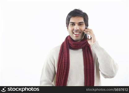 Portrait of young man having conversation on mobile phone over white background