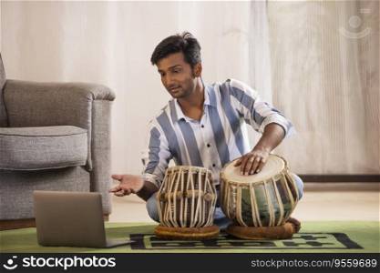 Portrait of young man having online Tabla lesson
