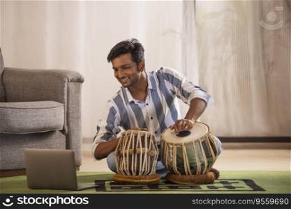 Portrait of young man having online Tabla lesson