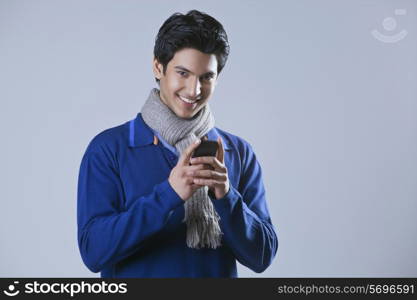 Portrait of young man holding mobile phone