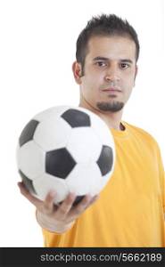 Portrait of young man holding soccer ball over white background