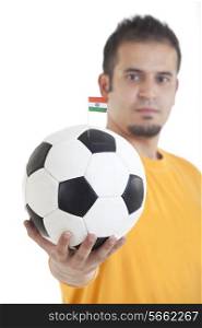 Portrait of young man holding soccer ball with small Indian flag on it over isolated on white background