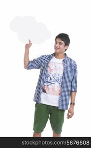 Portrait of young man holding thought bubble over white background