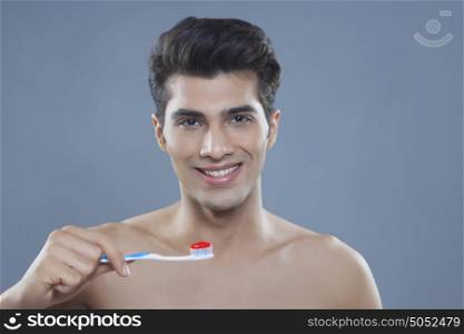 Portrait of young man holding toothbrush