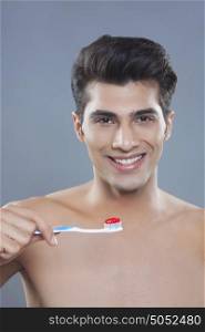 Portrait of young man holding toothbrush