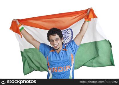 Portrait of young man in Indian cricket team jersey holding national flag over white background