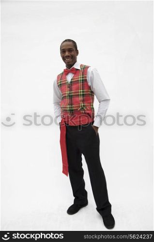 Portrait of young man in plaid vest and red bow tie, traditional clothing from Africa, studio shot