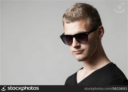 portrait of young man in sunglasses isolated on gray background with copyspace