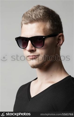 portrait of young man in sunglasses isolated on light background
