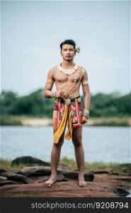 Portrait of Young man in traditional costume which Imagination image of Thailand literature about Serpent king, Folk tales based on the beliefs of the Isan people in Thailand, pose outdoor in nature