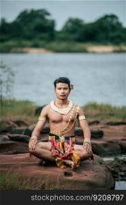 Portrait of Young man in traditional costume which Imagination image of Thailand literature about Serpent king, Folk tales based on the beliefs of the Isan people in Thailand, pose outdoor in nature