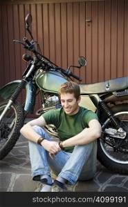 Portrait of young man leaning on motorbike