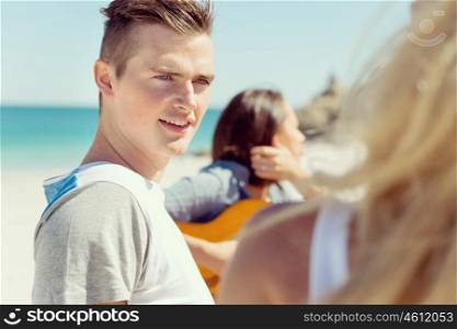 Portrait of young man on beach. Portrait of young man on beach with his friends on background