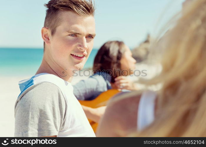 Portrait of young man on beach. Portrait of young man on beach with his friends on background