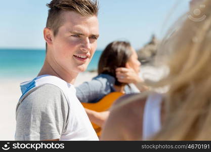 Portrait of young man on beach. Portrait of young man on beach with his friends on background