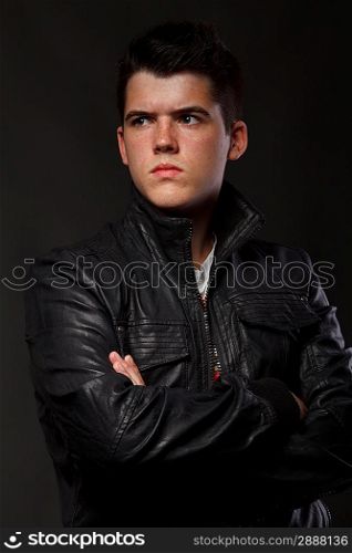 Portrait of young man over dark background.