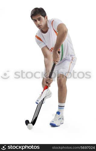 Portrait of young man playing field hockey isolated over white background