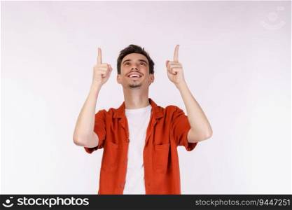Portrait of young man pointing fingers at copy space isolated on white studio background. Smiling guy advertising product or service.