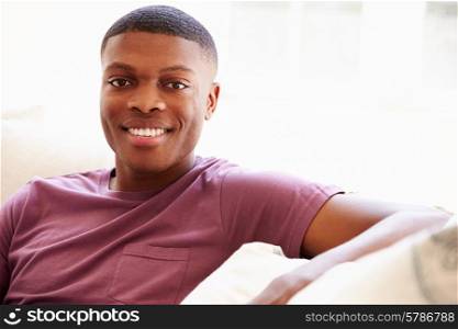 Portrait Of Young Man Relaxing Sitting On Sofa